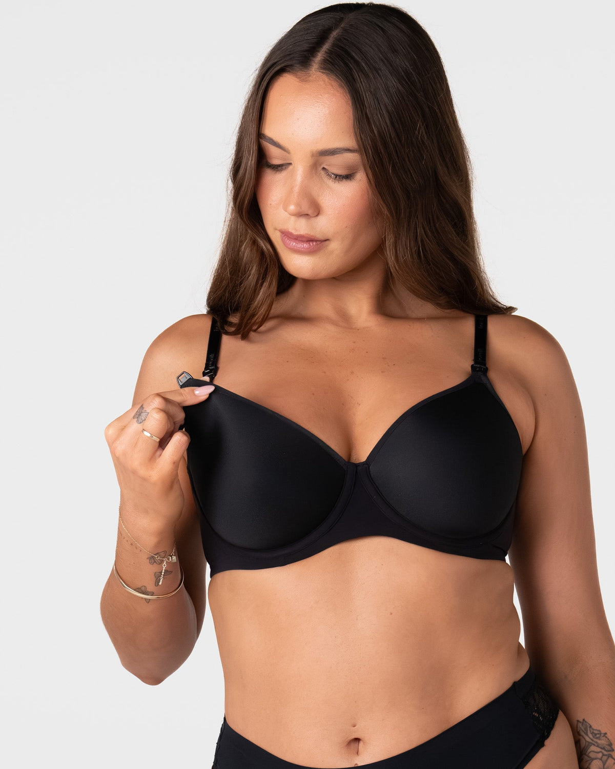 Model unclipping the traditional nursing clip on the Forever New black breastfeeding bra with drop-down cup for easy feeding access