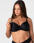 Model unclipping the traditional nursing clip on the Forever New black breastfeeding bra with drop-down cup for easy feeding access